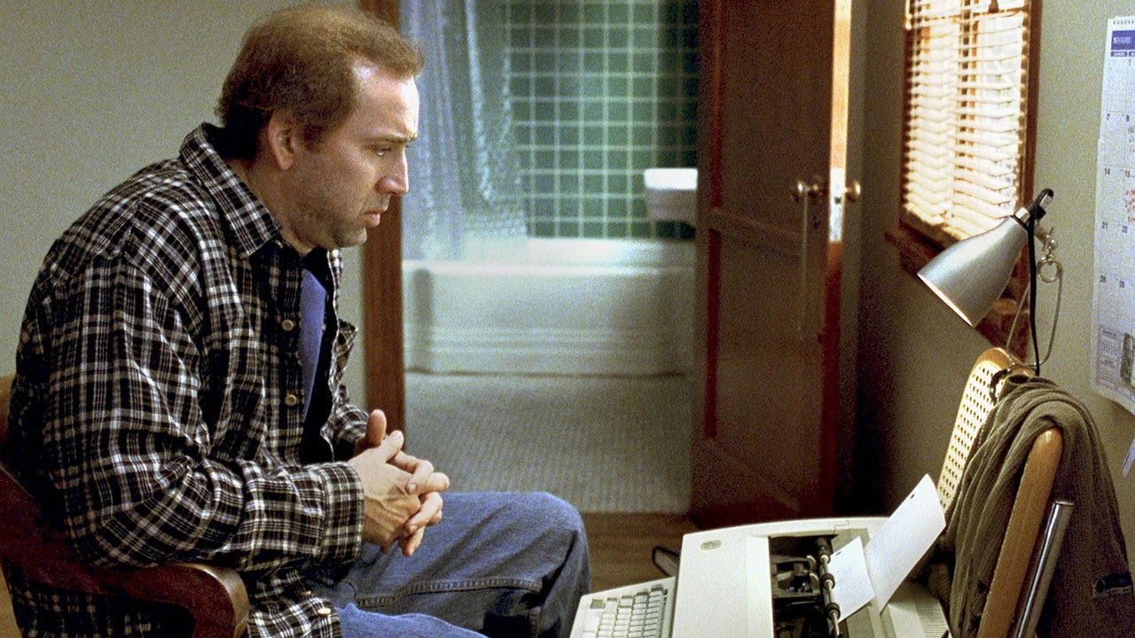 Charlie staring at his typewriter, hands clasped