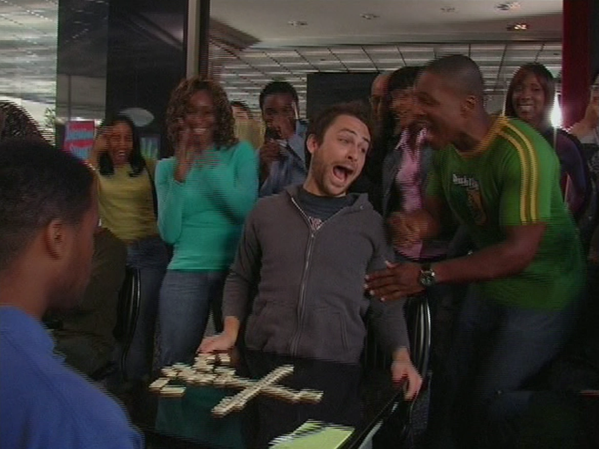 Still from It's Always Sunny S01E01: Charlie fits in over dominoes