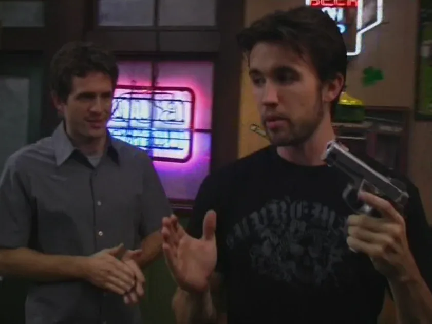 Still from It's Always Sunny S01E05: Mac and Dennis with the gun